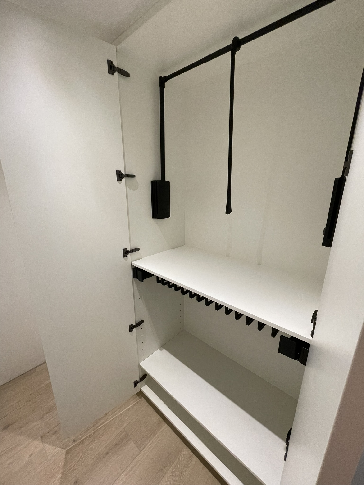Zwarte kledinglift in de dressing in mat wit
