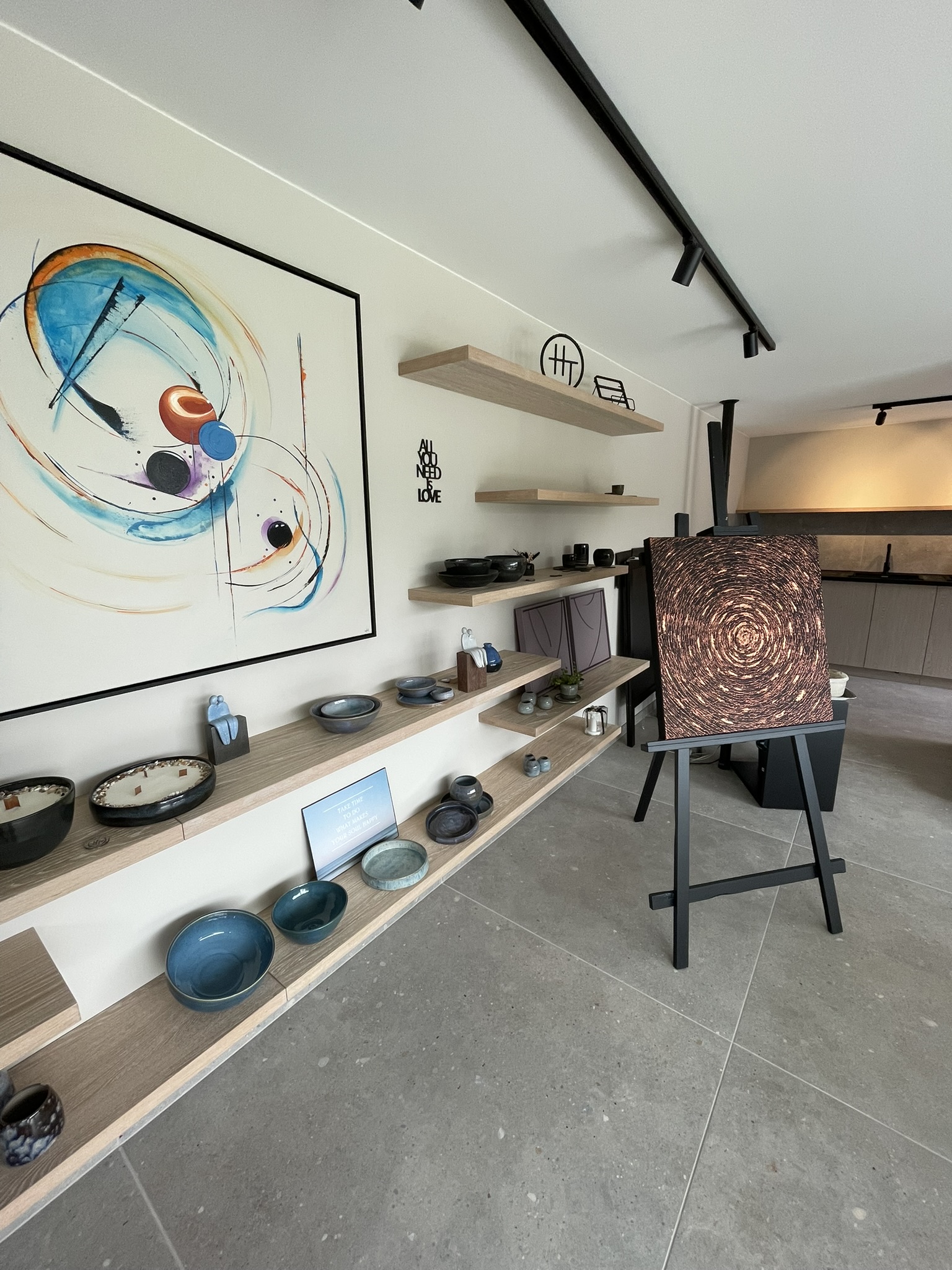 Massieve wandplanken gevuld met keramiek en werk uit het atelier